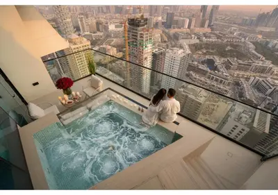 a couple sitting in a hot tub on the top of a building at Elegant 1BR Apartment in Binghatti Royale with Balcony in Dubai