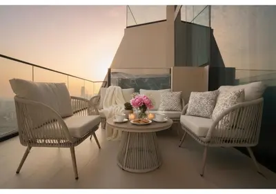 a living room with chairs and a table with flowers on it at Elegant 1BR Apartment in Binghatti Royale with Balcony in Dubai