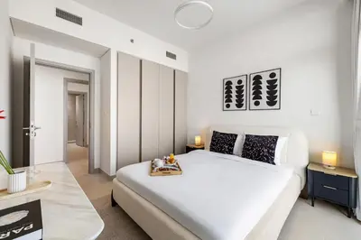 a bedroom with a white bed and a couch at BLVD-Manhattan Vibes 4BR High Floor Creek in Dubai