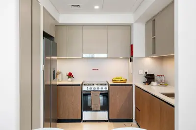 a kitchen with white cabinets and a stove at BLVD-Manhattan Vibes 4BR High Floor Creek in Dubai
