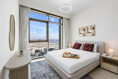 a bedroom with a large bed and a large window at BLVD-Manhattan Vibes 4BR High Floor Creek in Dubai