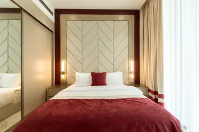 a bedroom with a large bed with a red blanket at Premium 1BR Suite at Binghatti Royale with City Views in Dubai
