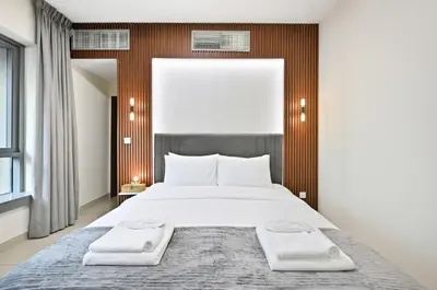 a bedroom with a large bed with two towels on it at Luxury 1BR, Long Stays & Walk to Burj Khalifa, High Speed Internet in Dubai