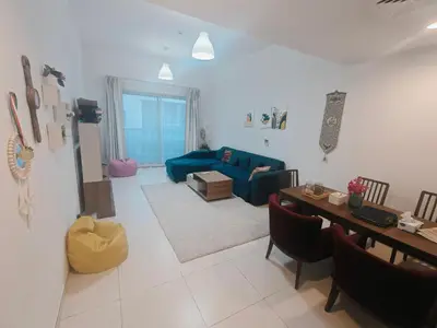 a living room with a blue couch and a table at 2 Bedroom Furnished Apartment in Dubai