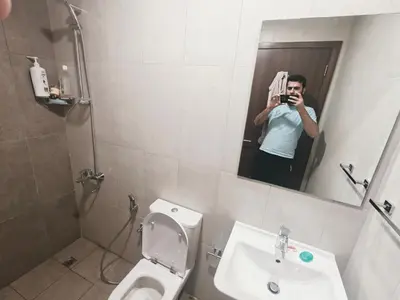 a man taking a picture of a bathroom mirror at 2 Bedroom Furnished Apartment in Dubai