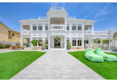 a large white mansion with a green lawn at Signature Palm Villa Ultra-Luxury 5 BDR Retreat in Dubai