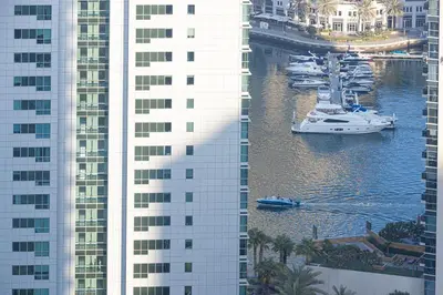 a group of boats in the water between two tall buildings at 2BR Near to Beach JBR Dubai Eye & Sea View SV 2805 in Dubai