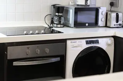 a kitchen with a washing machine and a microwave at 2BR Near to Beach JBR Dubai Eye & Sea View SV 2805 in Dubai