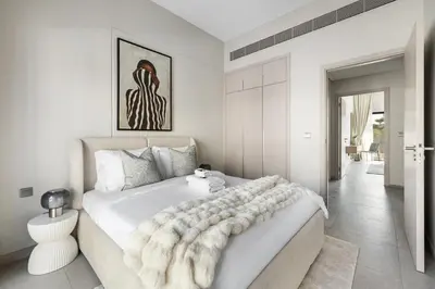 a white bedroom with a large white bed with a blanket at Family 4BR Villa | PS5 & Garden | New Community in Dubai