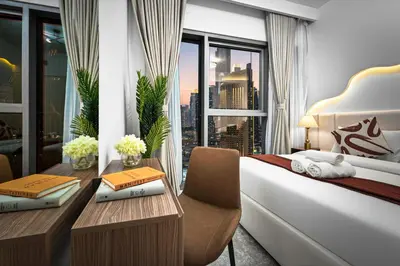a hotel room with a bed and a desk and a window at 2BR Burj View - Downtown Views 2 - Dubai Mall Access in Dubai