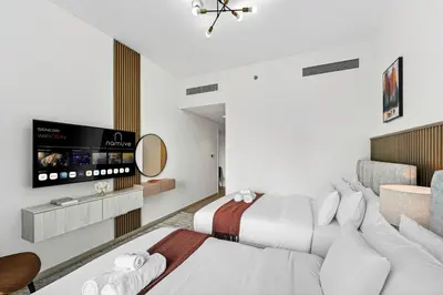 a hotel room with two beds and a flat screen tv at 2BR Burj View - Downtown Views 2 - Dubai Mall Access in Dubai