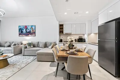 a kitchen and living room with a table and a couch at 2BR Burj View - Downtown Views 2 - Dubai Mall Access in Dubai