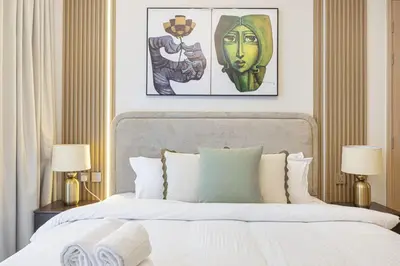a bedroom with a bed and two paintings on the wall at 1BR VIDA Dubai Mall - LUXURY DOWNTOWN DUBAI STAY - NAMUVE in Dubai