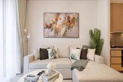 a living room with a couch and a painting on the wall at 1BR VIDA Dubai Mall - LUXURY DOWNTOWN DUBAI STAY - NAMUVE in Dubai