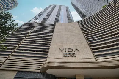 a tall building with a sign on the side of it at 1BR VIDA Dubai Mall - LUXURY DOWNTOWN DUBAI STAY - NAMUVE in Dubai