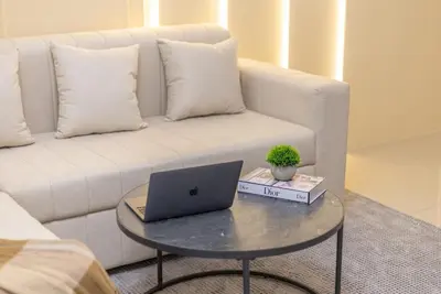 a laptop on a table in front of a couch at Luxury 3 BR in Dubai Marina By dPie DEC 2003 in Dubai