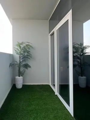 a room with two potted plants and a glass door at Modern 1-Bedroom Luxury Stay with Lake View in Reva, Business Bay in Dubai