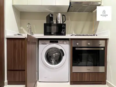 a kitchen with a washing machine and a sink at Modern 1-Bedroom Luxury Stay with Lake View in Reva, Business Bay in Dubai