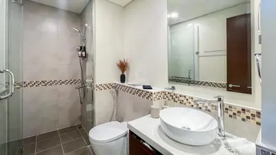 a bathroom with a toilet and a sink and a shower at Modern 1-Bedroom Luxury Stay with Lake View in Reva, Business Bay in Dubai