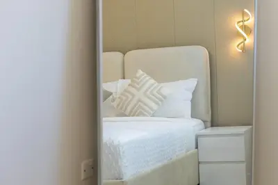 a mirror reflection of a white bed with pillows at Luxury 3 BR in Dubai Marina By dPie DEC T1 503 in Dubai