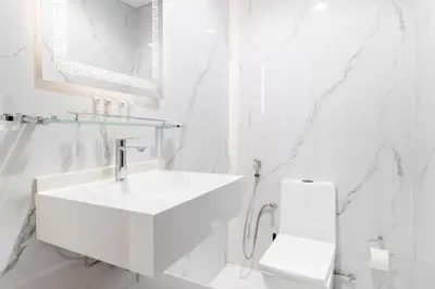 a white bathroom with a sink and a mirror at Luxury 3 BR in Dubai Marina By dPie DEC T1 503 in Dubai