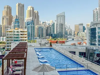 a swimming pool on the roof of a building with a city at Luxury 3 BR in Dubai Marina By dPie DEC T1 503 in Dubai