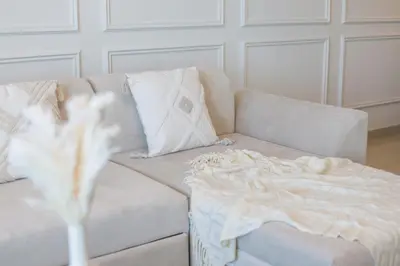 a white couch with a white blanket on it at Luxury 3 BR in Dubai Marina By dPie DEC T1 503 in Dubai