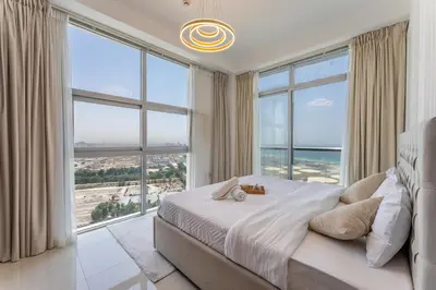 a bedroom with a large bed with large windows at Luxury 3 BR w Private Jacuzzi in Marina DEC 2203 in Dubai