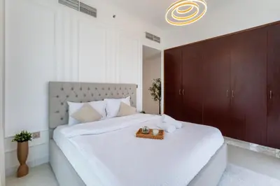 a bedroom with a large white bed with a tray on it at Luxury 3 BR w Private Jacuzzi in Marina DEC 2203 in Dubai