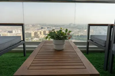 a wooden table with a potted plant on a balcony at Luxury 3 BR w Private Jacuzzi in Marina DEC 2203 in Dubai
