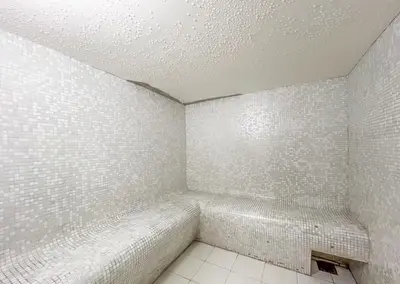 a bathroom with white tiled walls and a bench at Luxury 3 BR w Private Jacuzzi in Marina DEC 2203 in Dubai