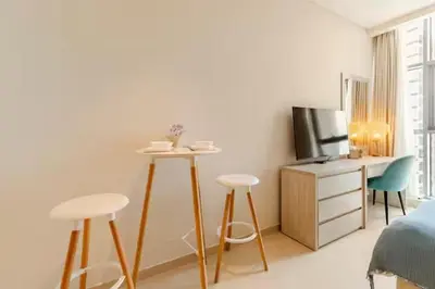 a room with a bed and a table and two stools at Studio in Seven Palm in Dubai
