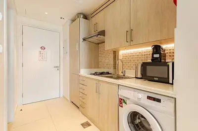 a kitchen with a washing machine and a microwave at Studio in Seven Palm in Dubai