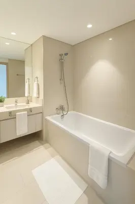 a white bathroom with a tub and a sink at Burj Khalifa Area- 2 Chic BR, Act Tower Dubai Mall in Dubai