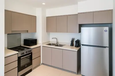 a kitchen with a refrigerator and a sink at Burj Khalifa Area- 2 Chic BR, Act Tower Dubai Mall in Dubai