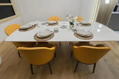 a dining room table with chairs and a white table with plates at Luxury Marina View 2BR Apartment for 6 in Dubai