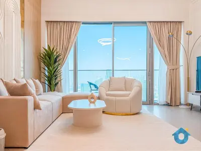 a living room with a couch and a chair at Wake up To Burj Khalifa Views Luxury 2 BR LikeHome in Dubai
