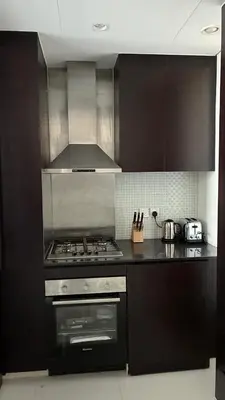 a kitchen with a stove and a stove top oven at Damac Maison The Distinction 1 BHK Burj Khalifa in Dubai