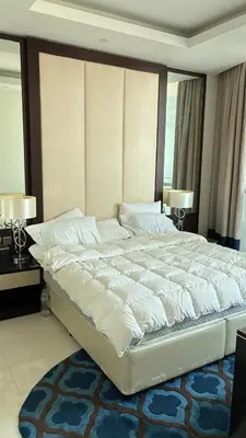 a large bed in a bedroom with two lamps at Damac Maison The Distinction 1 BHK Burj Khalifa in Dubai