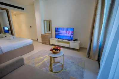 a living room with a bed and a television at Luxury Studio with Private Jacuzzi at Trillionaire, Business Bay in Dubai