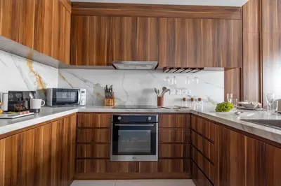 a kitchen with wooden cabinets and a stove top oven at Frank Porter - Blvd Central in Dubai