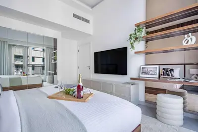 a living room with a bed and a flat screen tv at Frank Porter - Blvd Central in Dubai