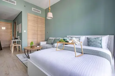 a bedroom with a white bed and a couch at Frank Porter - Studio One Tower in Dubai