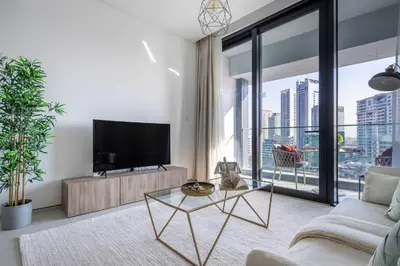 a living room with a tv and a large window at Frank Porter - Address Beach Resort Tower in Dubai