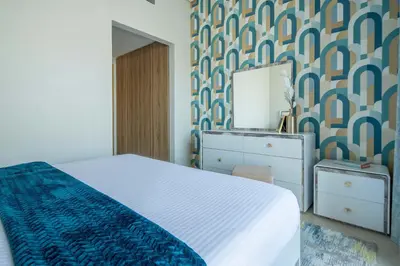 a bedroom with a bed and a dresser and a mirror at Frank Porter - Eleganz 2 by Danube in Dubai