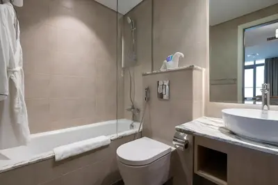a bathroom with a sink and a toilet and a tub at 2BR Apartment in Paramount Midtown with Infinity Pool in Dubai