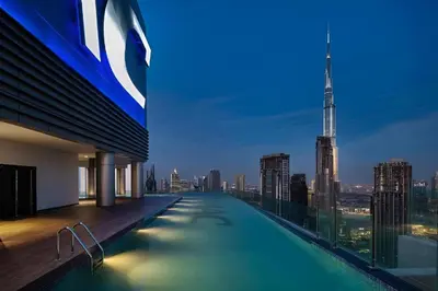 a swimming pool on the roof of a building with a city skyline at 2BR Apartment in Paramount Midtown with Infinity Pool in Dubai