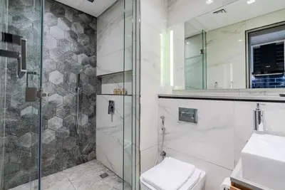 a bathroom with a glass shower and a toilet at TRPS - MAG 318, Business Bay - Walk to Dubai Mall, Furnished Apt, Premium Amenities in Dubai