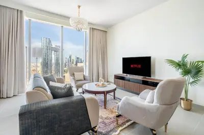 a living room with a couch and chairs and a tv at GuestReady - Forte Tower | Steps from Dubai Mall in Dubai
