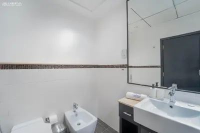 a white bathroom with two sinks and a mirror at SkyView Tower - Dubai Marina View - Lit Apartment in Dubai